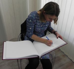 Eliza Piotrowska dokonuje wpisu do kroniki biblioteki