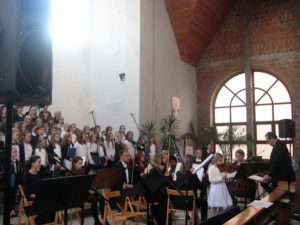 Połączone chóry, Orkiestra kameralna z Legnicy, gra Matylda Kościelska, dyryguje Benedykt Księdzyna